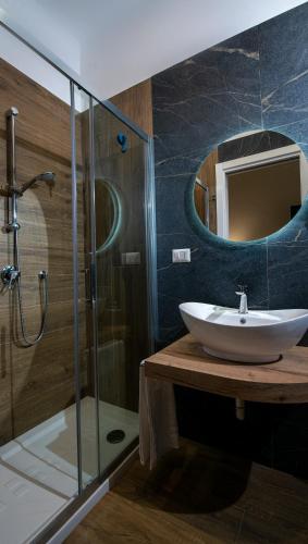 a bathroom with a sink and a shower with a mirror at VIVI A NAPOLI in Naples