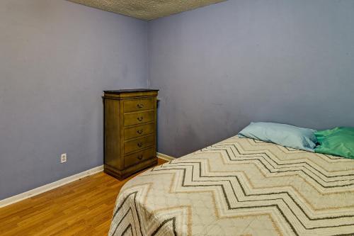 a bedroom with a bed and a wooden dresser at Fayetteville Vacation Rental with Yard! in Fort Bragg