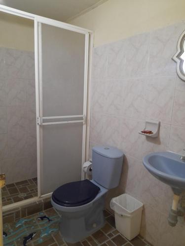 uma casa de banho com um WC azul e um lavatório. em Posada Henry Sede Centro em San Andrés