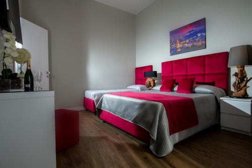 a bedroom with two beds and a red headboard at VIVI A NAPOLI in Naples