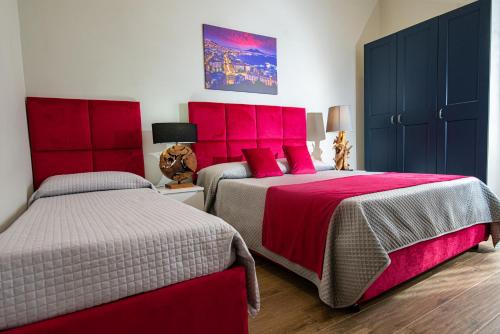 a bedroom with two beds with red headboards at VIVI A NAPOLI in Naples