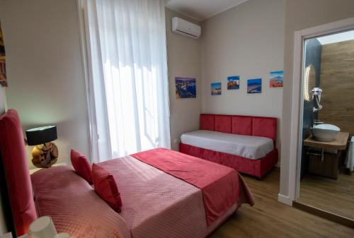 a bedroom with two beds and a bathroom with a sink at VIVI A NAPOLI in Naples