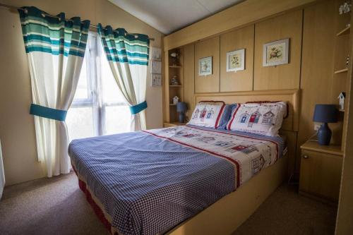 1 dormitorio con cama y ventana en Great 6 Berth Caravan For Hire At Manor Park In Hunstanton Norfolk Ref 23014w, en Hunstanton