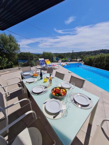 - une table avec des assiettes et un bol de fruits sur la terrasse dans l'établissement Villa Mekasteni, à Cirendinu