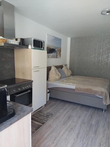 mały pokój z łóżkiem i kuchnią w obiekcie Appartement Daniel Kaprun w Kaprunie