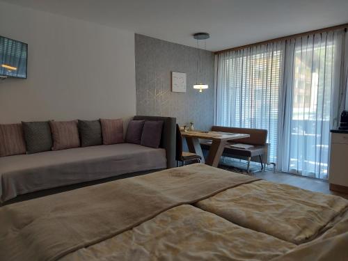 sypialnia z łóżkiem, kanapą i stołem w obiekcie Appartement Daniel Kaprun w Kaprunie