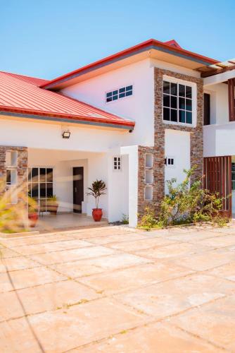 a house with a red roof at Lovely 4 Bedroom Solar Powered House with CCTV and Unlimited WiFi near Devtraco Court Community 25 Tema in Tema