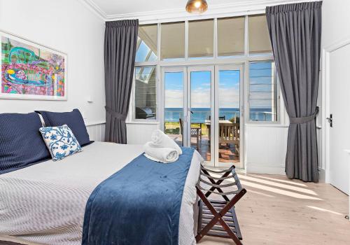 a bedroom with a bed and a large window at Hamptons Escape in Gerroa