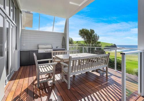 a porch with two benches and a table and a grill at Hamptons Escape in Gerroa