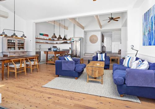 a living room with two blue couches and a table at Hamptons Escape in Gerroa