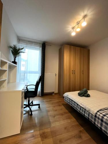 a bedroom with a bed and a desk and a chair at Downtown Apartment in Krakow