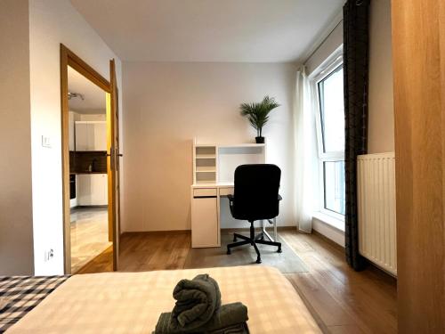 a bedroom with a bed and a desk and a chair at Downtown Apartment in Krakow