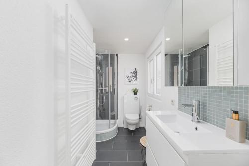 a white bathroom with a toilet and a sink at Lemon Suites: Traumhaus in Filderstadt in Filderstadt