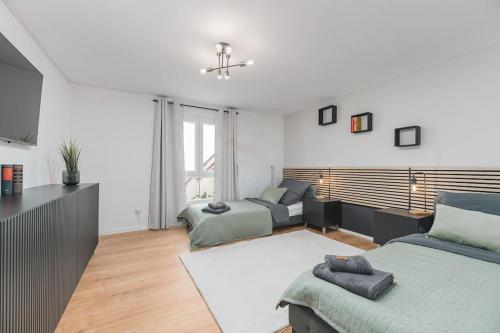 een woonkamer met 2 bedden en een bank bij Lemon Suites: Traumhaus in Filderstadt in Filderstadt