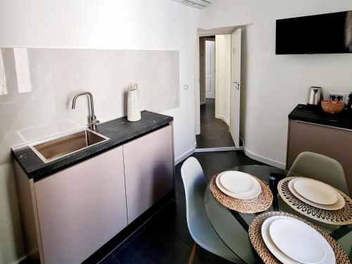 a kitchen with a sink and a table with plates on it at Lena Suite Bari Vecchia in Bari