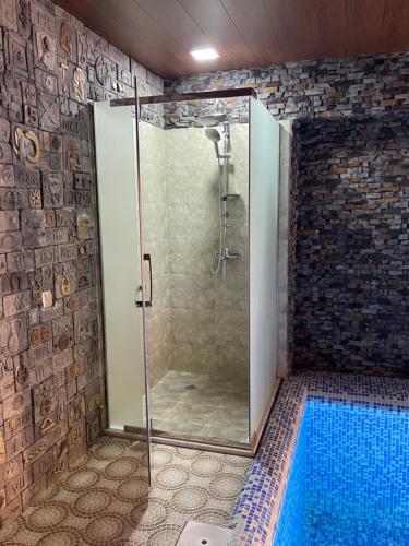 y baño con ducha y puerta de cristal. en Premium VILLA (LUXURY Mansion), en Şamaxı