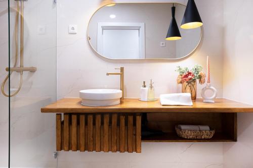 ein Bad mit einem Waschbecken und einem Spiegel in der Unterkunft Coimbra Premium Downtown in Coimbra