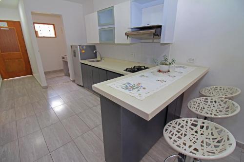 a kitchen with a counter and stools in it at Apartahotel La Villa Santa fe de Antioquia in Santa Fe de Antioquia