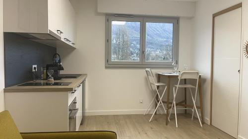 a kitchen with a counter and a table with chairs at L'innovalé - Inria / Naver Labs in Meylan