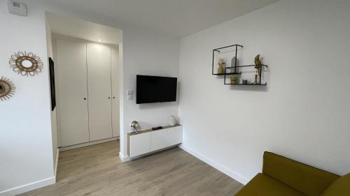 sala de estar con TV y pared blanca en L'innovalé - Inria / Naver Labs, en Meylan