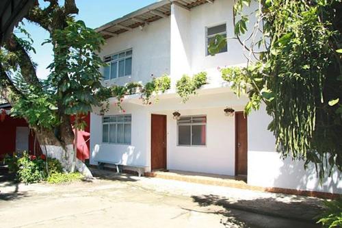 une maison blanche avec un banc devant elle dans l'établissement Pousada Cirandinha - P1, à Itajaí