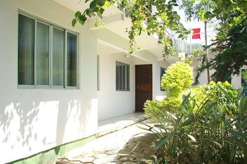una casa blanca con una puerta y algunas plantas en Pousada Cirandinha - P1, en Itajaí