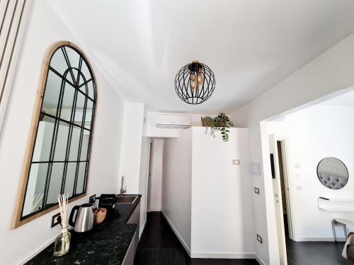 a kitchen with white walls and a black counter top at Lena's Suites Bari Vecchia in Bari