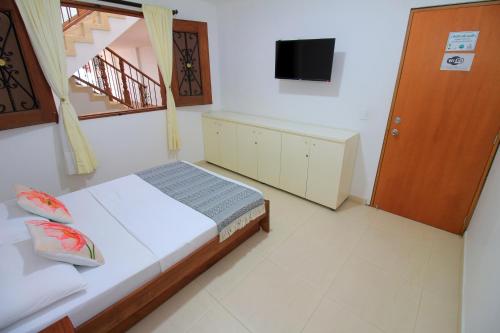 a bedroom with a bed and a television in it at Apartahotel La Villa Santa fe de Antioquia in Santa Fe de Antioquia