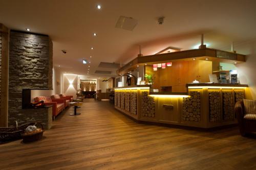 a lobby with a bar and a living room at Panoramahotel Kühbergalp in Gunzesried