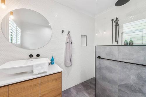 a bathroom with a sink and a mirror and a shower at The Sunrise Cubby House in Sunrise Beach