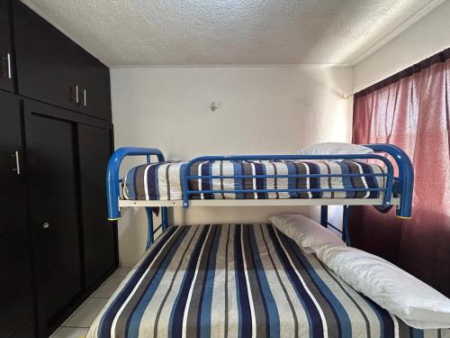 um beliche num quarto com um tapete listrado em Relajante casa con alberca & auto check-in em Mazatlán