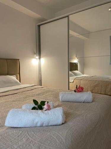 a bedroom with two towels on a bed with a mirror at Golden Apartment in Skopje