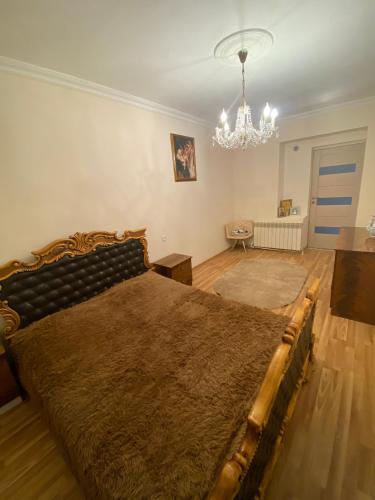 a bedroom with a large bed and a chandelier at Shirakatsi Guest House in Gyumri