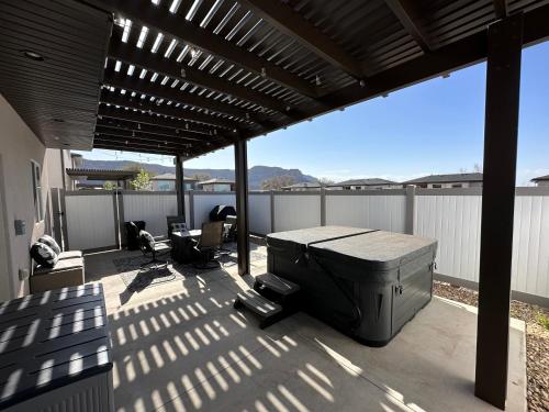 a patio with a grill and chairs on a roof at South Zion Coral Cliffs - 4 bed, 3 bath, hot tub, deck in Hildale