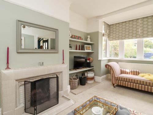 a living room with a fireplace and a mirror at The Kingsway in Ilkley