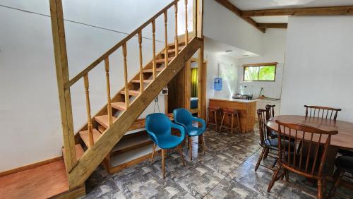 a room with a wooden staircase and a table and chairs at Cabañas Manuto in Hanga Roa