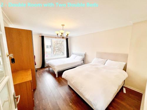 1 dormitorio con 2 camas dobles y ventana en Centel - Excellent Stay in London Zone 1, en Londres