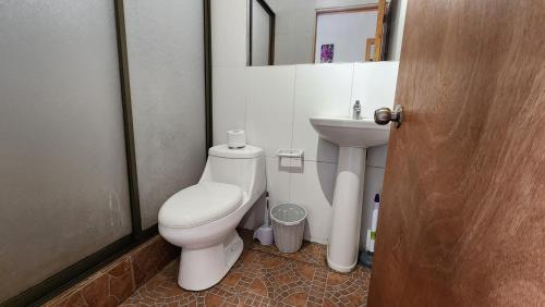 a bathroom with a toilet and a sink at Cabañas Manuto in Hanga Roa