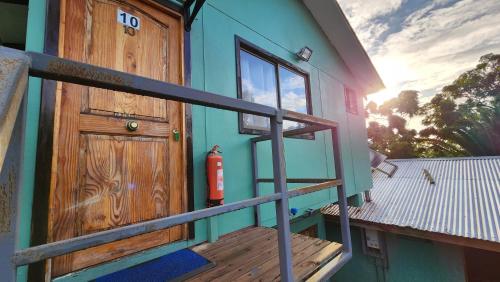 a house with a wooden door and a wooden stairs at Cabañas Manuto in Hanga Roa