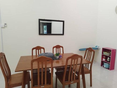 a dining room table with four chairs and a mirror at Homestay Delisha Tapah-Pool in Tapah