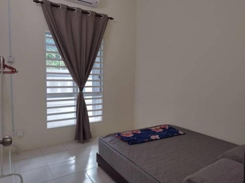 a bedroom with a bed and a window at Homestay Delisha Tapah-Pool in Tapah