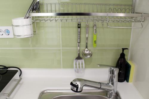 a kitchen sink with a kitchen utensils on a wall at Ever8 Serviced Residence in Seoul