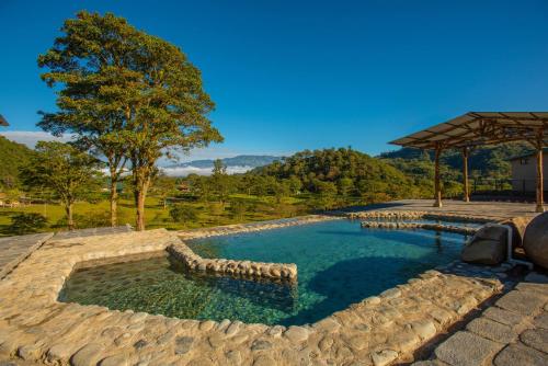 a large swimming pool with a stone path around it at Coffee Pickers Village By Hacienda Orosi in Cartago