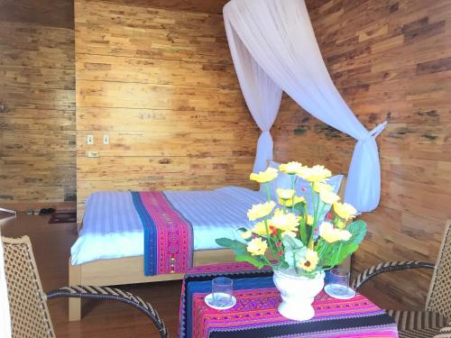 a table with a vase of flowers on it at Sau Meo Mountain View in Sa Pa