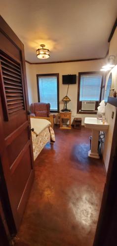 a living room with a door and a couch and a table at Hootie Creek Guest House in Talihina