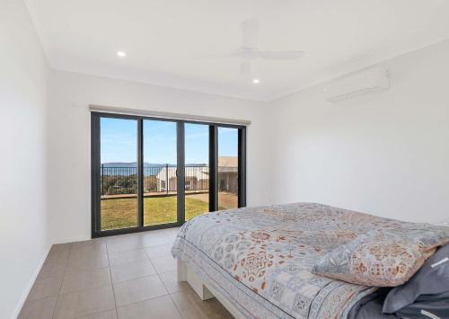 ein Schlafzimmer mit einem Bett und einem großen Fenster in der Unterkunft ESCAPE WITH A VIEW in Emu Park