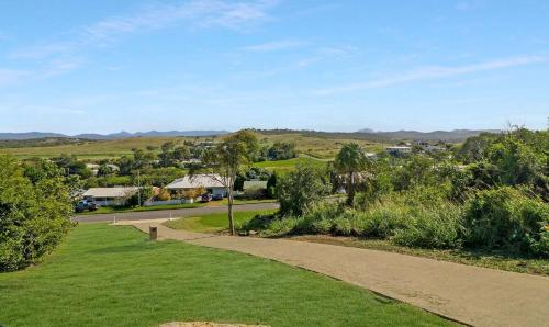 a walkway leading down to a park with trees and houses at ESCAPE WITH A VIEW in Emu Park