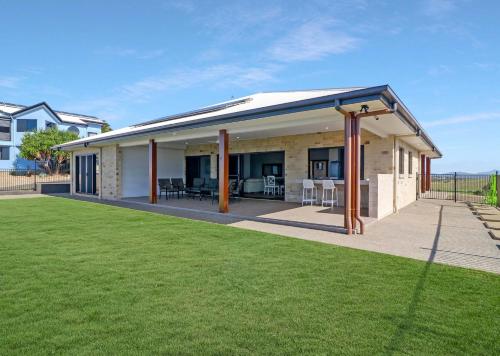 a home with a large backyard with green grass at ESCAPE WITH A VIEW in Emu Park