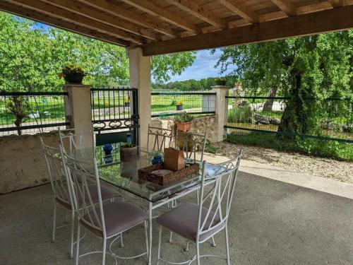 un patio avec une table et des chaises et une clôture dans l'établissement Charmante maison avec jardin privatif, proche des activités nature et des vignobles de Cognac - FR-1-653-221, à Saint-Sulpice-de-Cognac