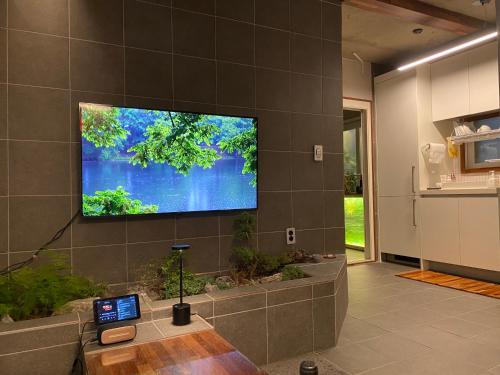 - un salon avec une grande télévision murale dans l'établissement Viva La Vida - Seochon Private Apartment, à Séoul